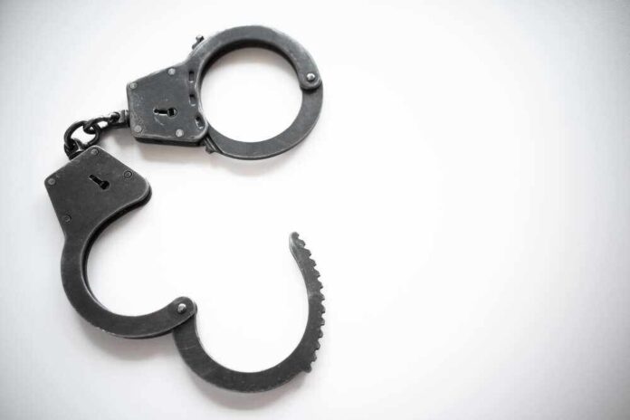 shutterstock_2116470560.jpg featured image Open metal handcuffs on white background.