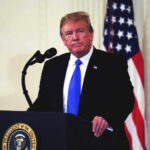 Donald Trump speaking at podium.