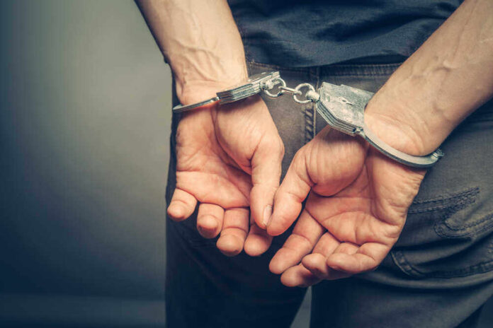 shutterstock_437224012.jpg featured image Person with handcuffs behind their back.