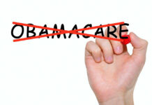 Hand crossing out the word Obamacare in red