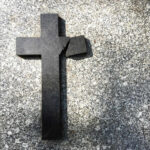 Christian Conservative Icon Dead Broken black cross on a gray surface.