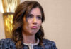 Kristi Noem with long dark hair frowns slightly.
