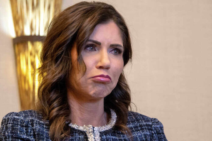 shutterstock_1962517696.jpg featured image Kristi Noem with long dark hair frowns slightly.