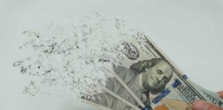 Hundred-dollar bills disintegrating in hand.