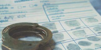 Handcuffs on a fingerprint document.