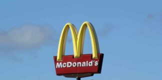 McDonald’s drive-thru sign against a blue sky.