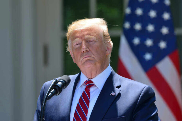 Donald Trump speaking with US flag in the back