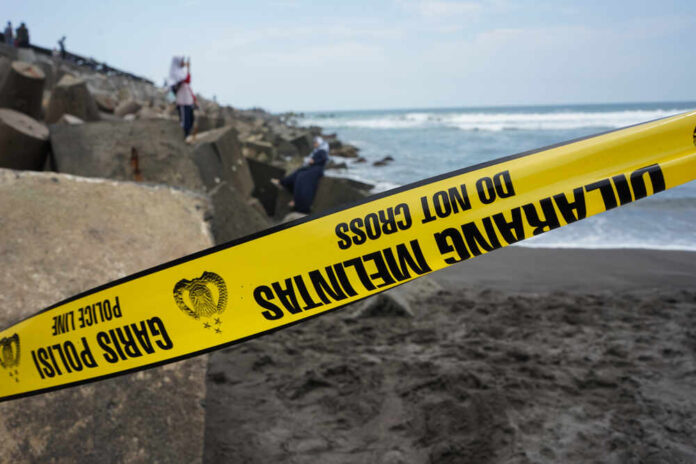 shutterstock_1599290890.jpg featured image Yellow police tape by rocky ocean shore
