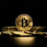 Gold Bitcoin coin on pile dark background