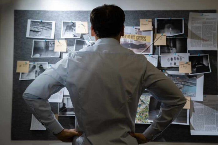 Man examining investigation board with photos and notes
