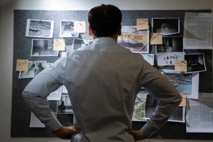 shutterstock_2140725125.jpg featured image Man examining investigation board with photos and notes.