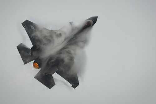 shutterstock_2601496309.jpg F-35 jet performing an aerial maneuver with smoke trailing behind