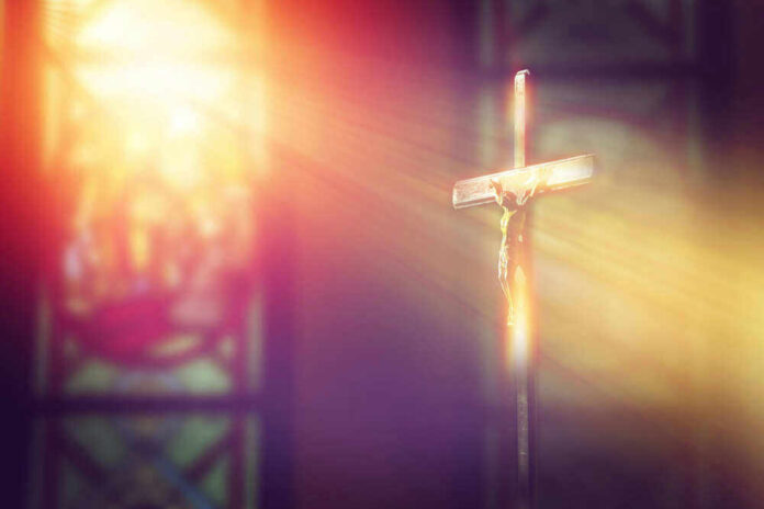 Crucifix with sunlight, stained glass window in background