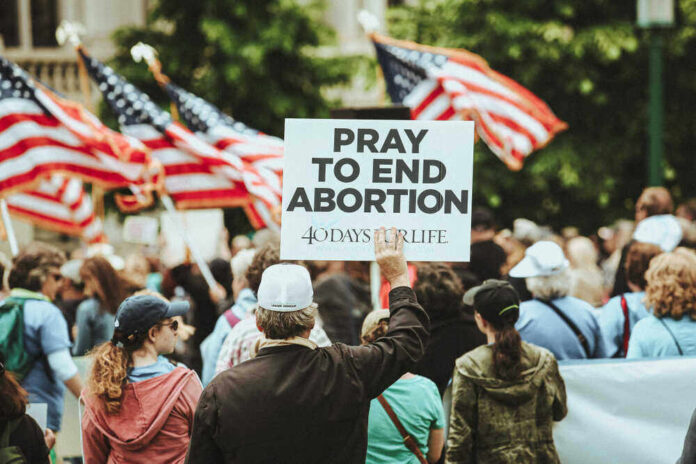 People holding a Pray to End Abortion sign
