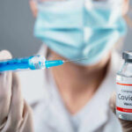 Doctor holding COVID19 vaccine vial and syringe
