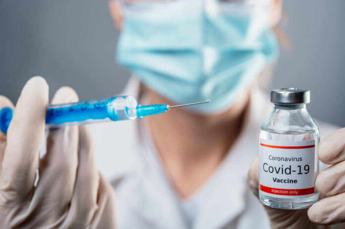 Doctor holding COVID19 vaccine vial and syringe