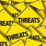 Explosive Threat Against Trump Sparks Alarm Yellow signs with the word threats overlapping