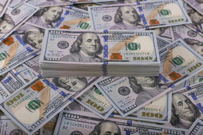 shutterstock_1257954658.jpg Stack of one hundred dollar bills, Benjamin Franklins portrait.