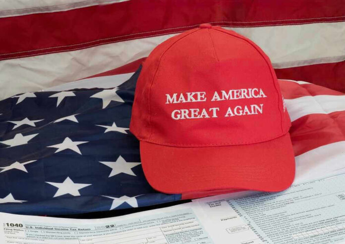 shutterstock_2240568885.jpg Red Make America Great Again hat on American flag