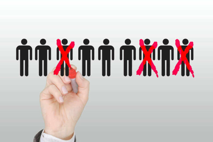 Hand crossing out stick figures with a red marker.