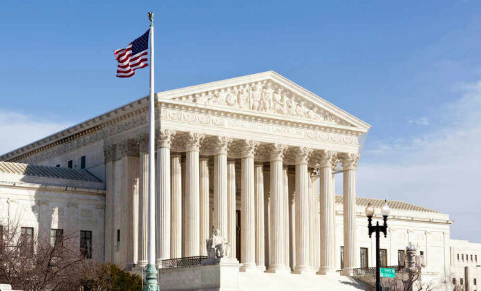 shutterstock_96721225.jpg U.S. Supreme Court building with American flag