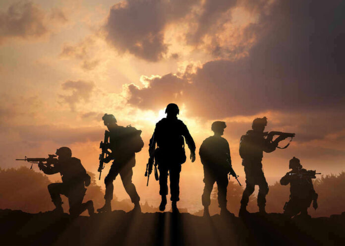 Silhouetted soldiers against a dramatic sunset sky.
