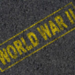 The words 'WORLD WAR II' printed in yellow on a dark asphalt surface