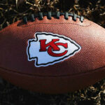 Kansas City Chiefs football lying on the grass.