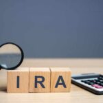 HUGE IRA Boost Coming — Nobody Expected This Magnifying glass and wooden blocks spelling 'IRA' next to a calculator
