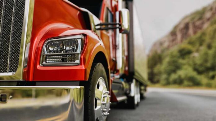 shutterstock_2490035203.jpg Close-up of a red truck on a road with a mountainous background