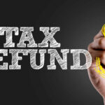 Hand writing 'TAX REFUND' with a dollar sign