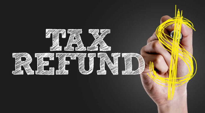 Hand writing 'TAX REFUND' with a dollar sign