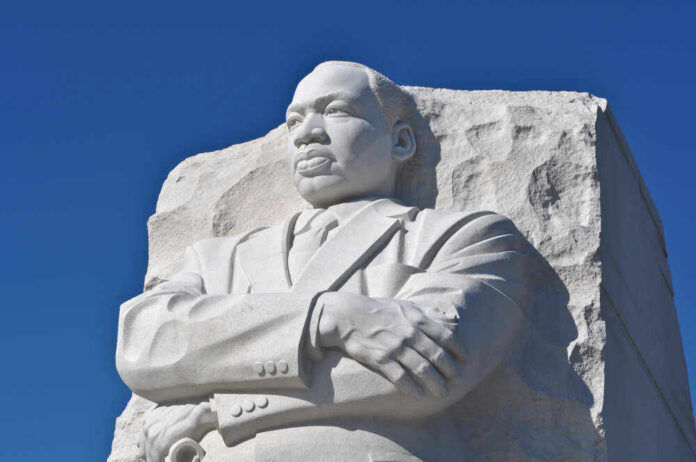 Martin Luther King Jr. statue against clear blue sky.