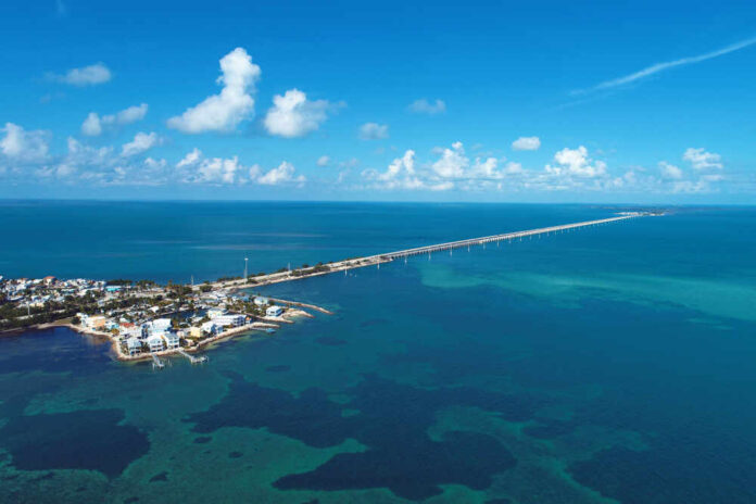 Aerial view of a coastal area with a long bridge extending over turquoise waters