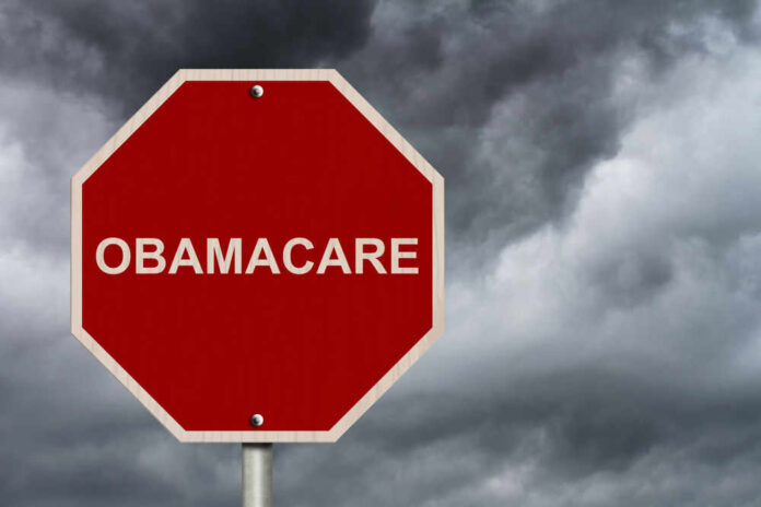 Red stop sign labeled Obamacare cloudy sky background