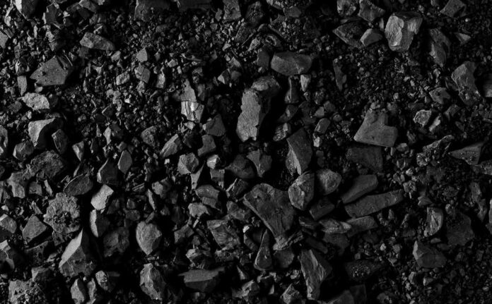 Close-up of black coal pieces scattered on a surface