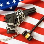 Supreme Court SLAMS Hawaii — Gun Ban COLLAPSING?! A handgun chained on an American flag with a gavel beside it