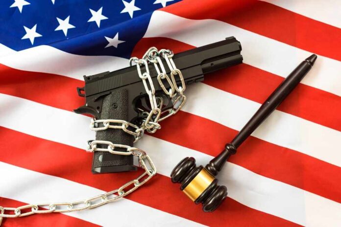 A handgun chained on an American flag with a gavel beside it