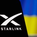 Starlink logo displayed on a smartphone with a Ukrainian flag in the background