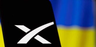 Starlink logo displayed on a smartphone with a Ukrainian flag in the background
