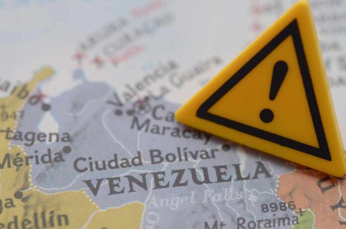 A close-up of a map of Venezuela with a yellow warning sign