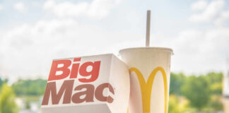 A Big Mac box next to a McDonald's drink cup on a ledge