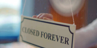 Closed forever sign being placed on window.