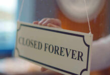 Closed forever sign being placed on window.