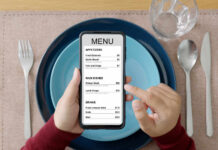 A person holding a smartphone displaying a restaurant menu with various food items