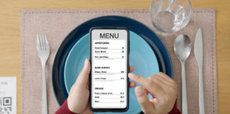 A person holding a smartphone displaying a restaurant menu with various food items