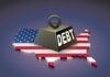 A heavy weight labeled 'DEBT' sits on a map of the United States, symbolizing economic challenges.