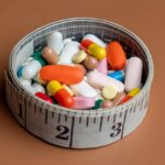 $49 Weight-Loss Pill Sparks Legal Battle A bowl filled with various colorful pills and capsules next to a measuring tape
