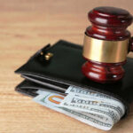 Gavel on wallet with visible dollar bills