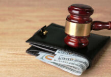 Gavel on wallet with visible dollar bills